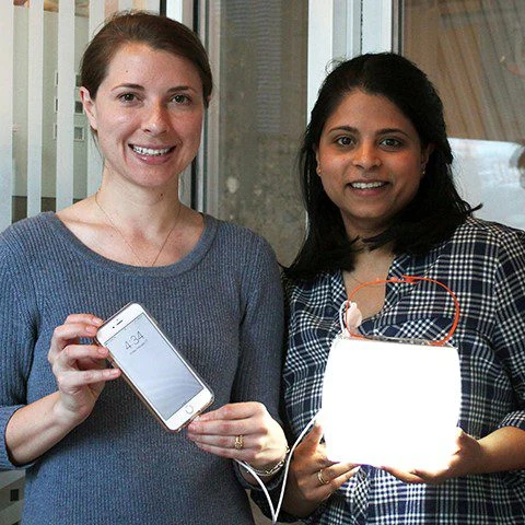 Anna Stork and Andrea Sreshta holding LuminAID lights